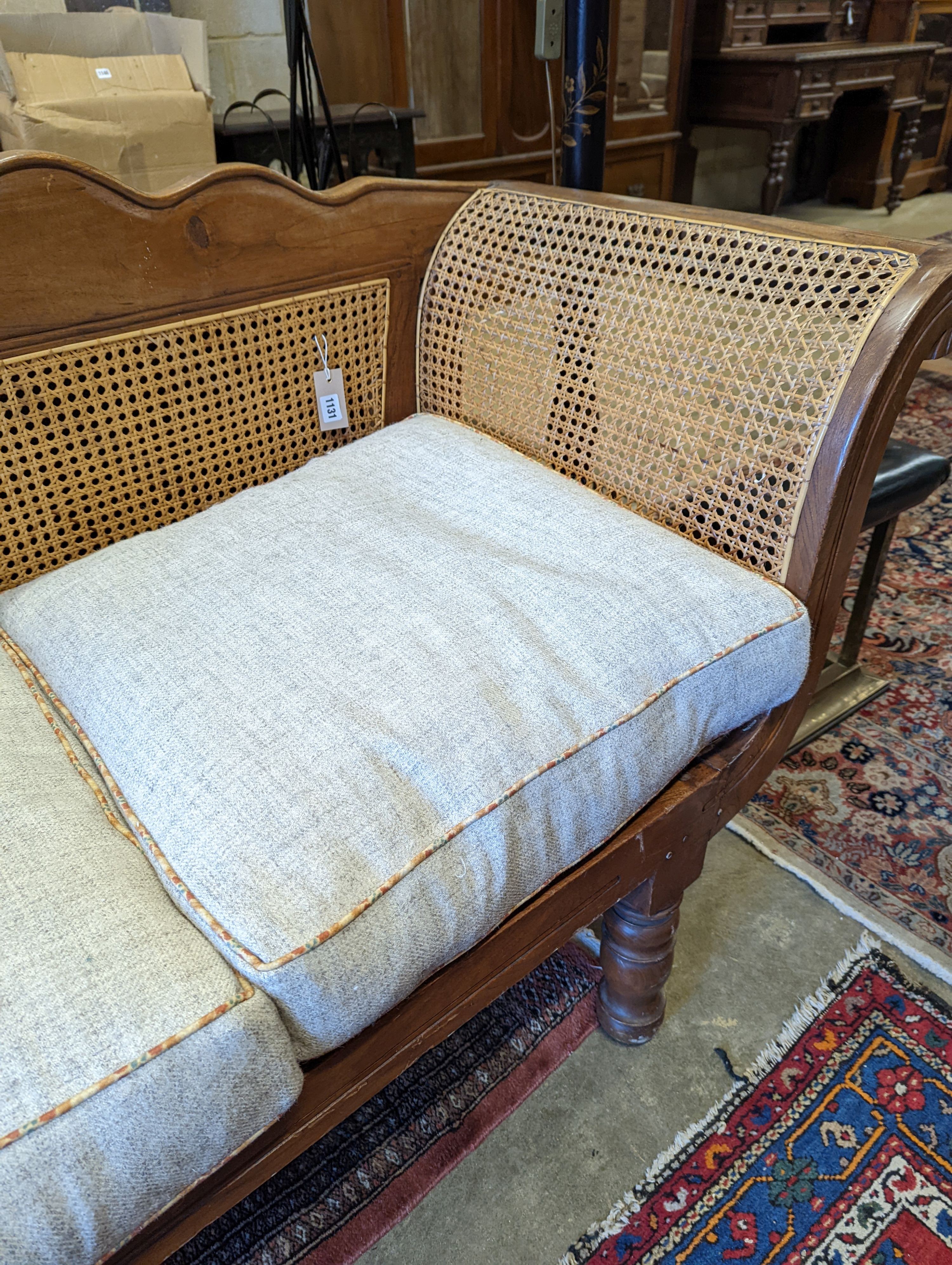 A Colonial caned teak settee with loose cushion seat, length 214cm, depth 62cm, height 95cm